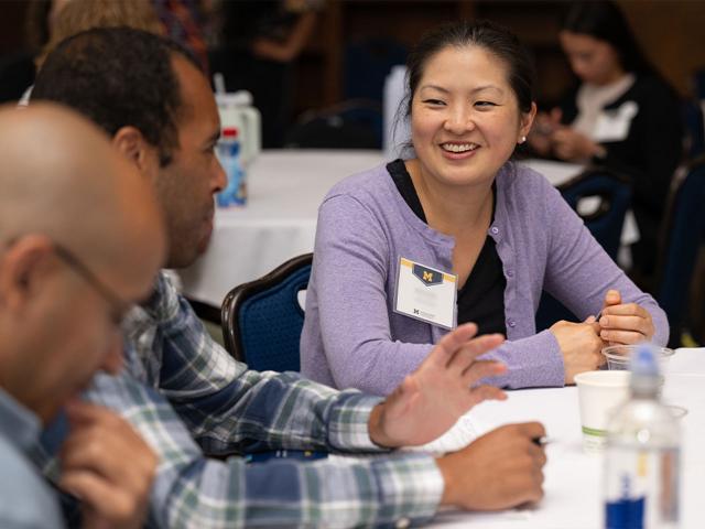 Two institute attendees speak while seated at a table in the Michigan Union